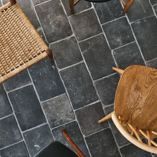 room with chateau designed floor tiles with wooden chair