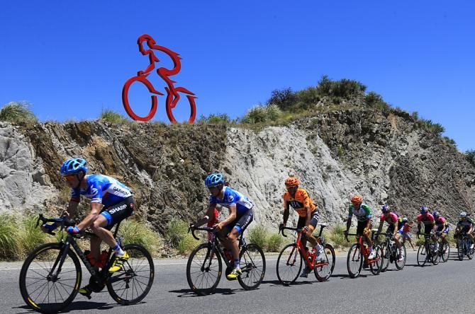 The Garmin-led peloton passes a cycling-centric sculpture