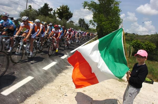 An Italian fan waves the flag on as the peloton passes during what would be the first stage of the Giro d'Italia won by an Italian.