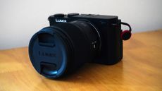 The Panasonic Lumix S9 on a wooden platform against a white background