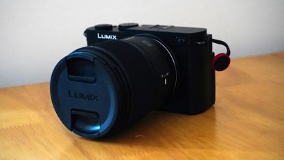 The Panasonic Lumix S9 on a wooden platform against a white background