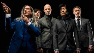 A Perfect Circle posing for a photograph wearing suits