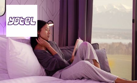 Woman reading book on the bed in her hotel room