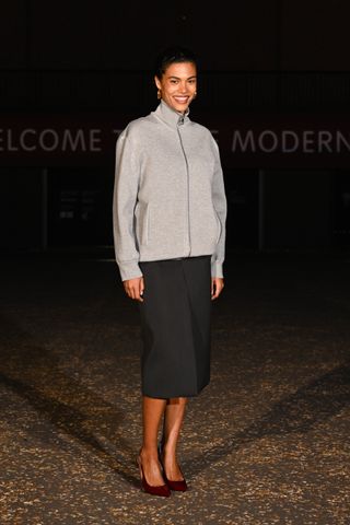 Tina Kunakey in a gray jacket and gray pencil skirt at the Gucci Cruise 2025 show.