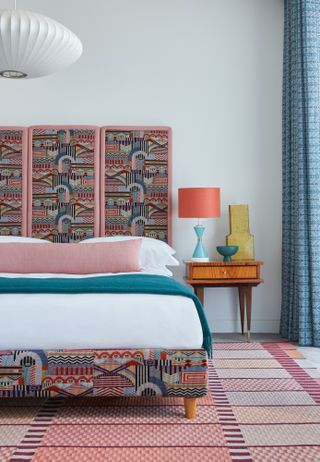 Patterned bedroom curtains and bed headboard in a colourful bedroom