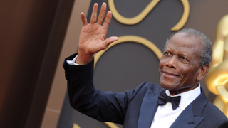 Sidney Poitier waves on the red carpet at the 86th Academy Awards