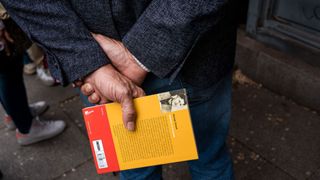 Person holding a copy of Animal Farm