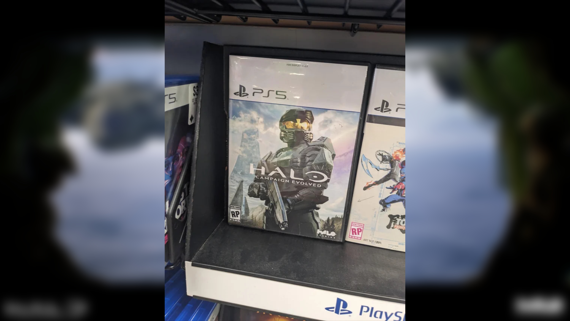 Placeholder PS5 case for Halo: Campaign Evolved displayed on a GameStop shelf beside other PlayStation 5 games.
