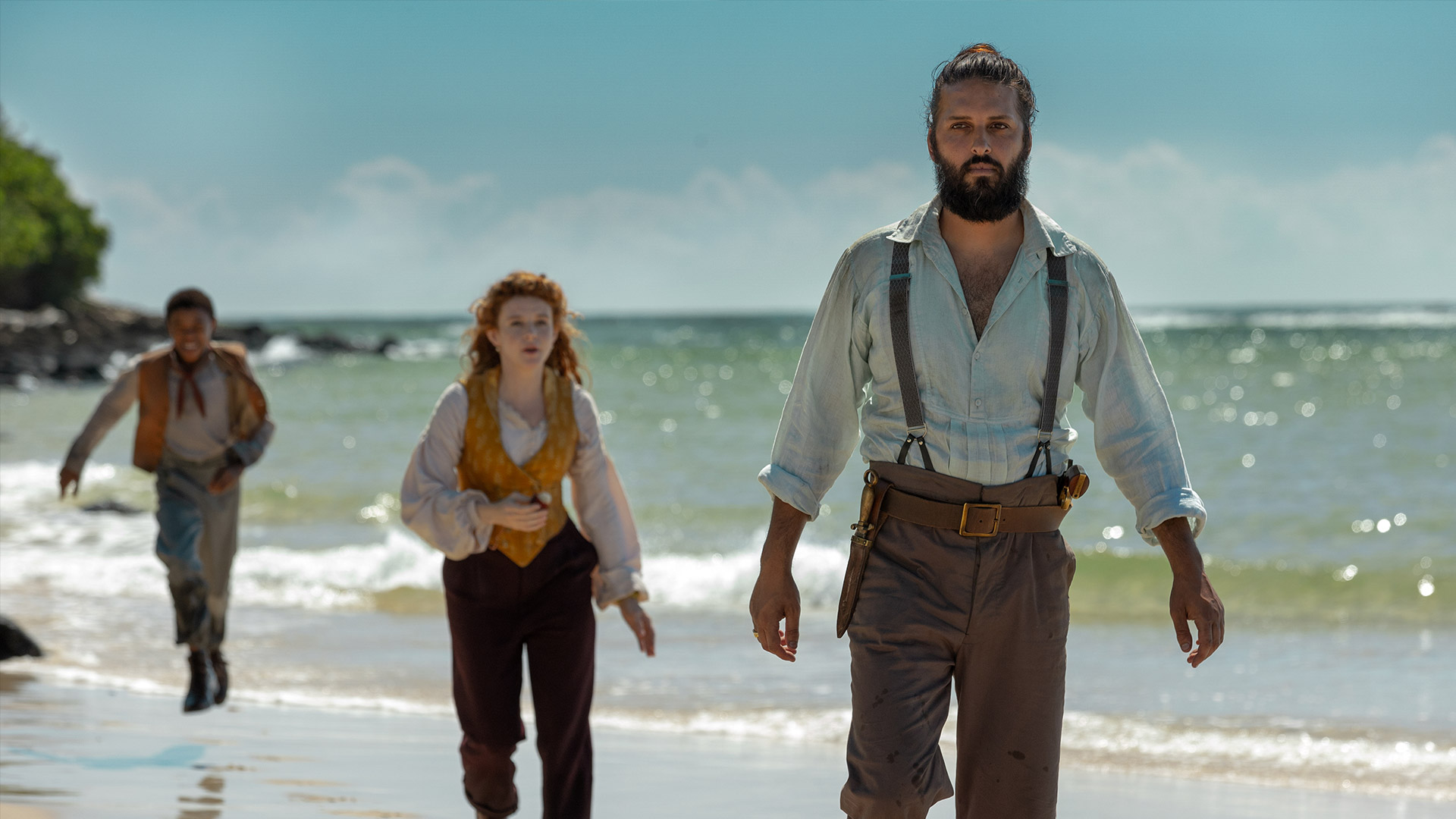 Three 19th century figures walking on a beach