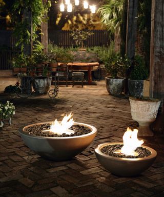 Two round fire pits in paved area