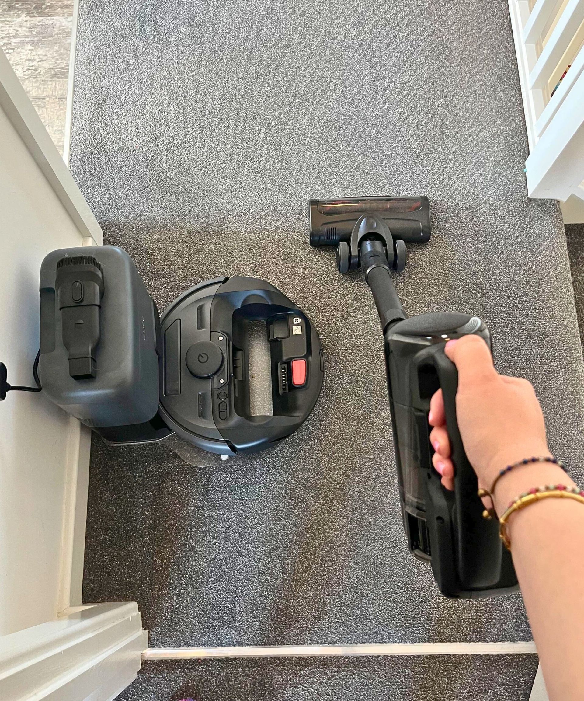 Using the eufy E20 in cordless and robot mode, pictured with the cordless eufy E20 in hand on gray carpet, with the robot housing docked next to it