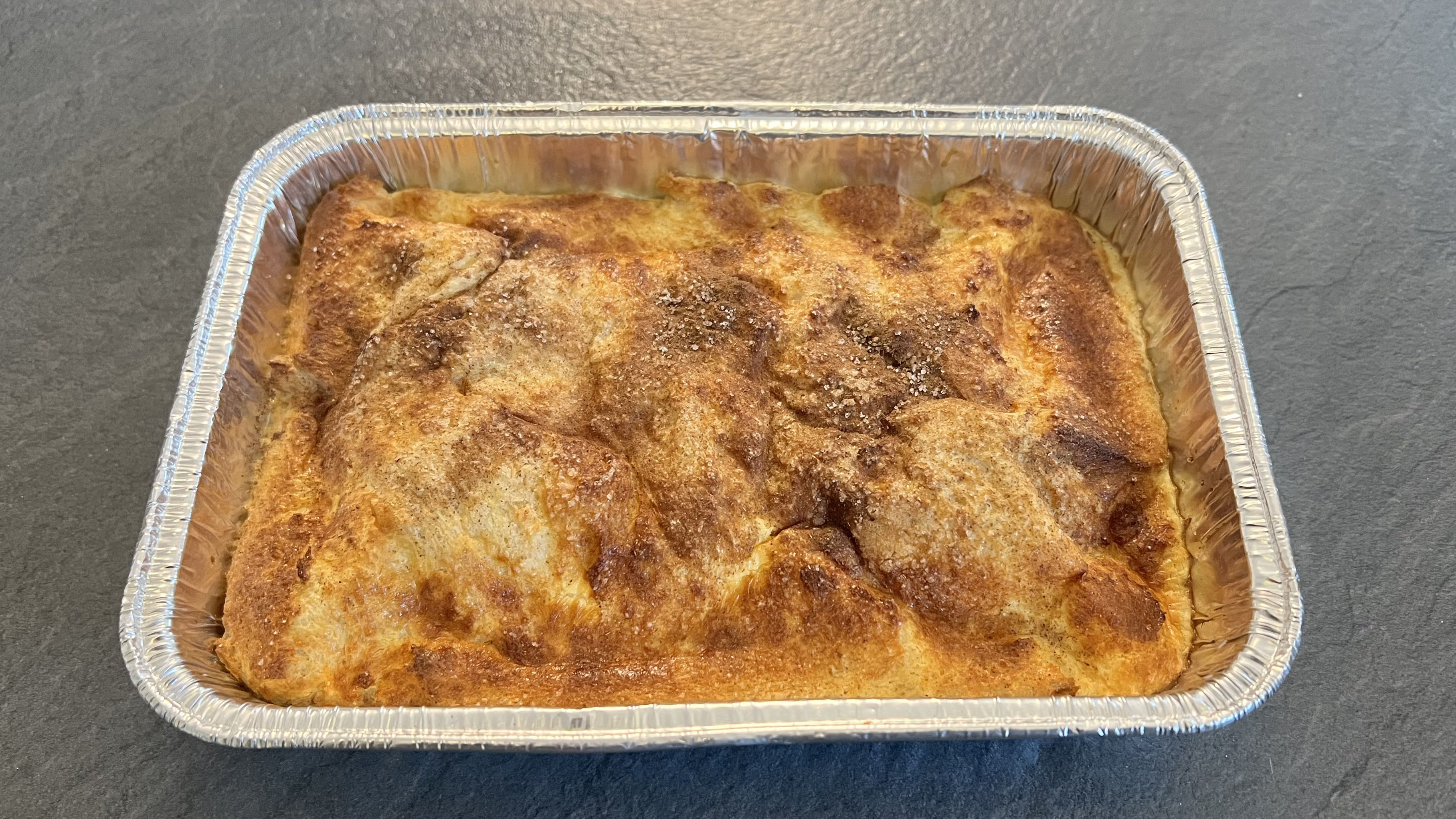 Budín de pan y mantequilla cocido en una bandeja de metal