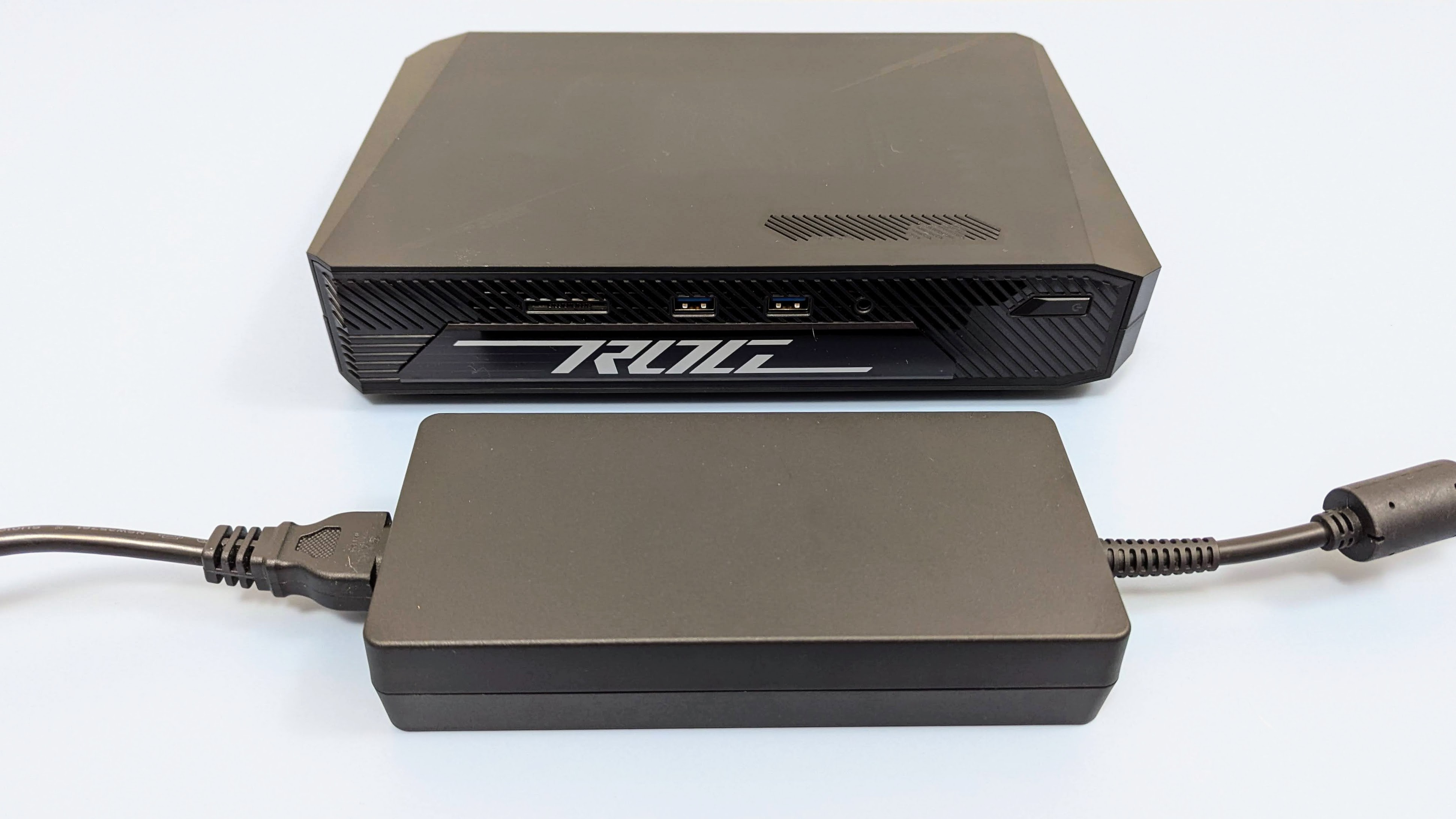 Asus ROG NUC 970 on a desk next to the very large power brick