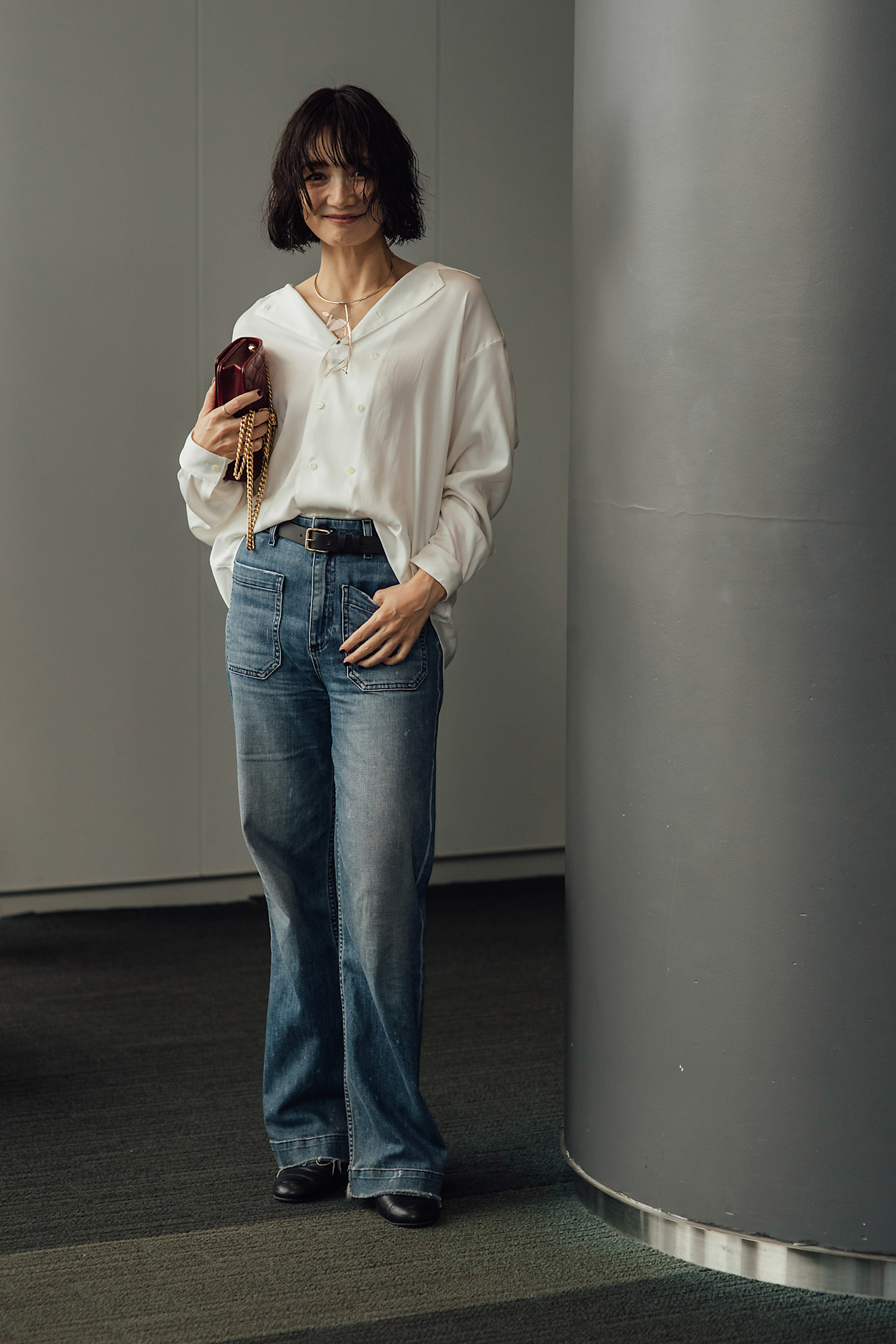 woman wearing a white button-down shirt and blue jeans.