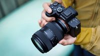 Tamron 35-100mm f/2.8 Di III VXD X being held by a photographer
