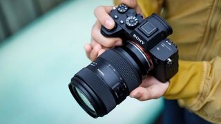 Tamron 35-100mm f/2.8 Di III VXD X being held by a photographer