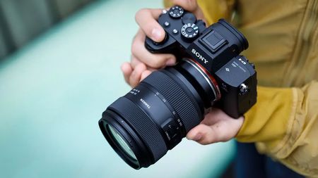 Tamron 35-100mm f/2.8 Di III VXD X being held by a photographer