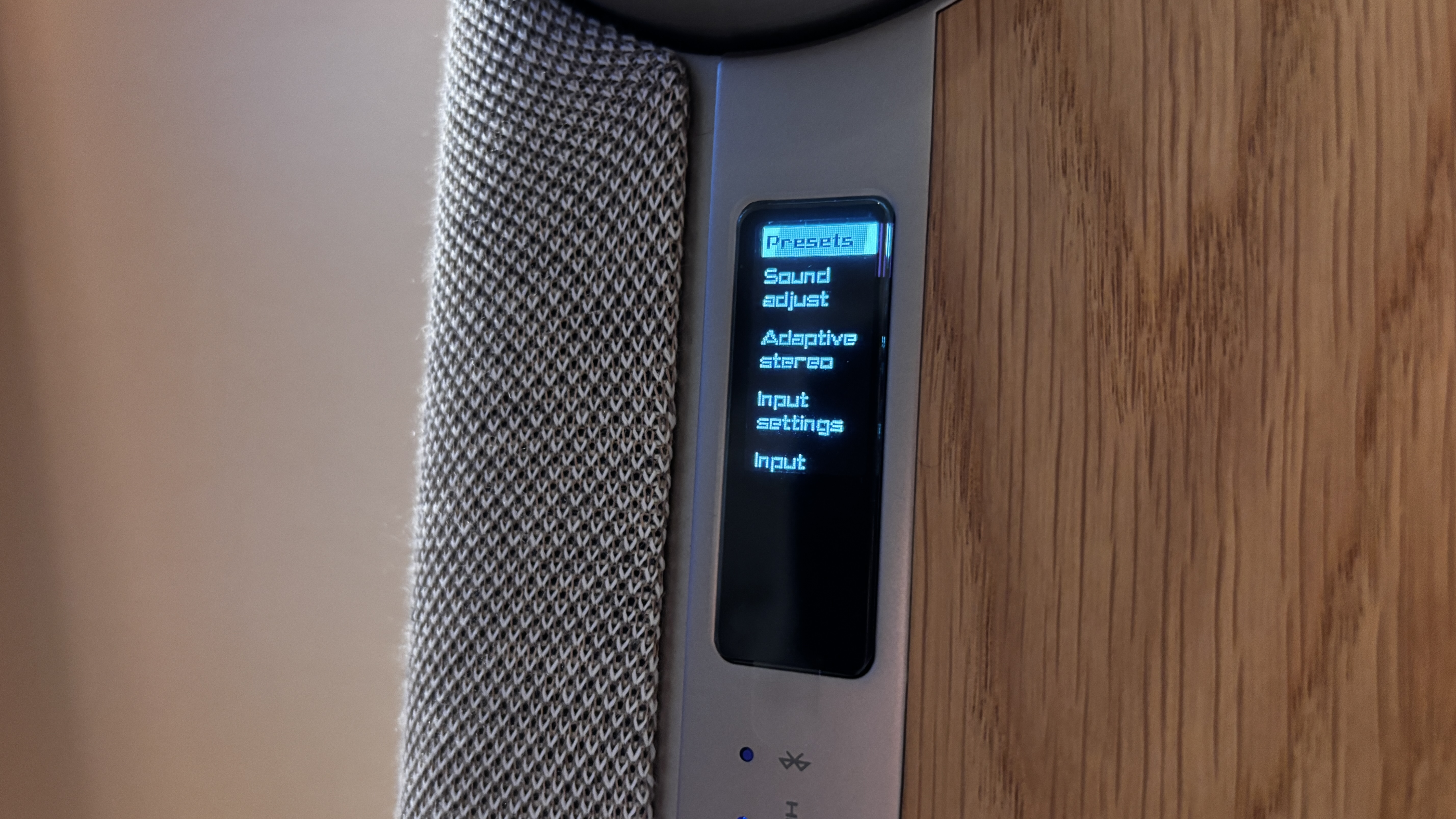 A small OLED display on the Dali Vega wireless sound system showing a menu for settings