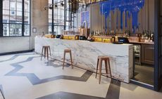 Bar area of the Shilling Brewing Company, Glasgow, UK with marble bar, metal stools and dripping paint effect on the wall