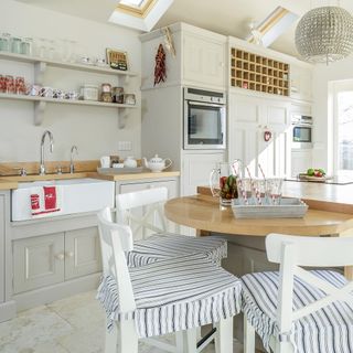 white kitchen with wooden countertop and white flooring