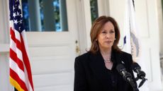 vice president kamala harris standing at a podium in front of an american flag