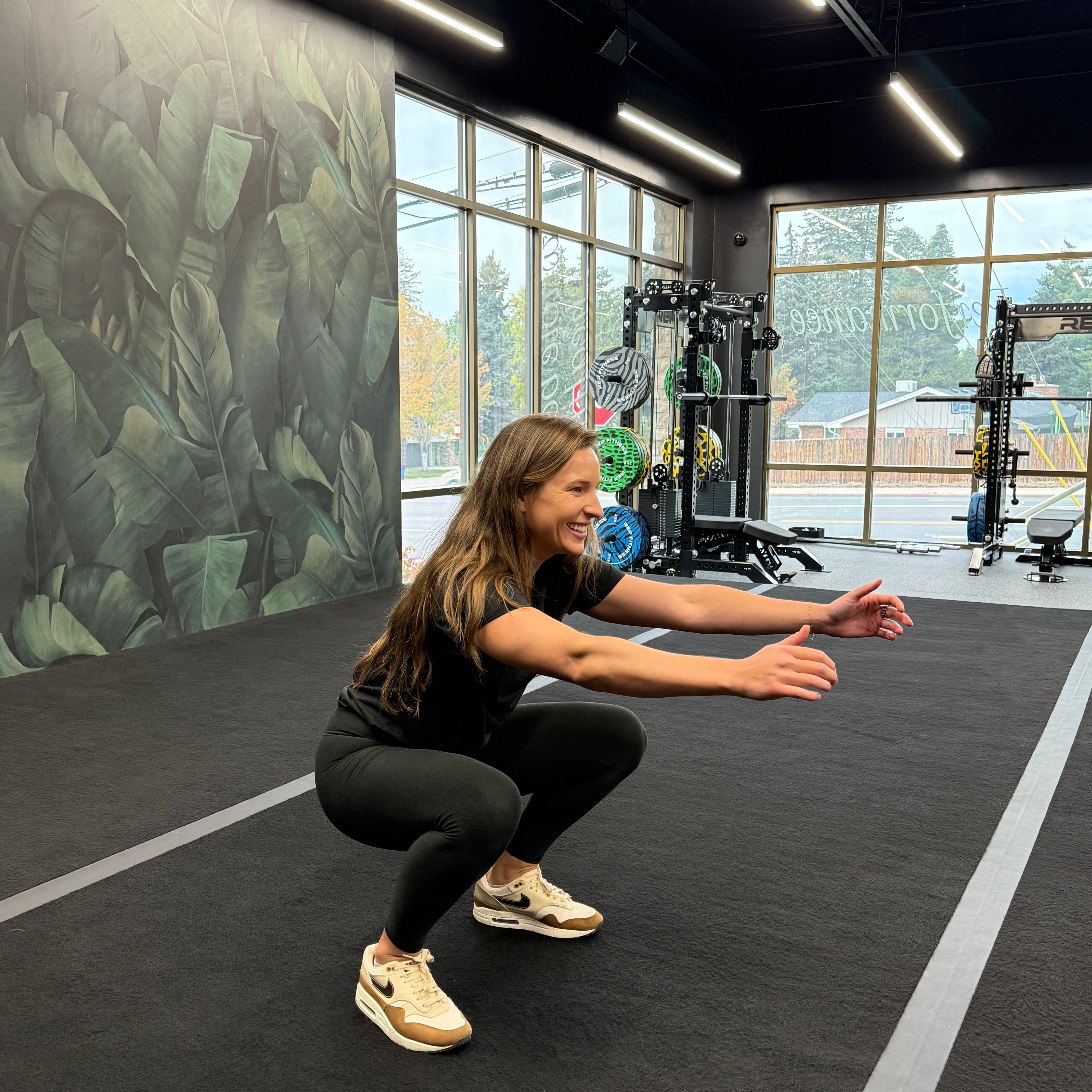 Woman demonstrates exercise in empty gym