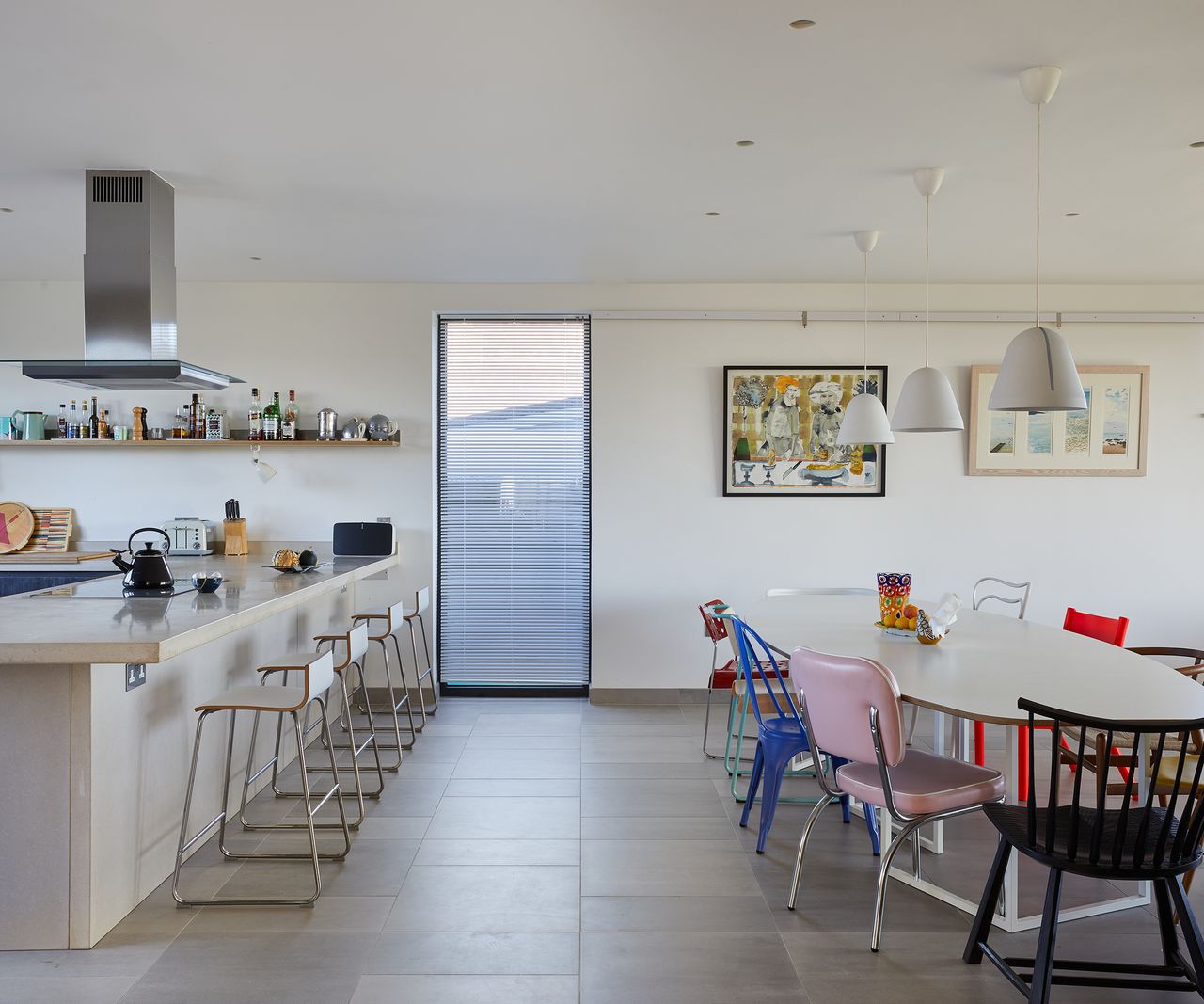 An open plan kitchen-diner with bar stools and a large dining table