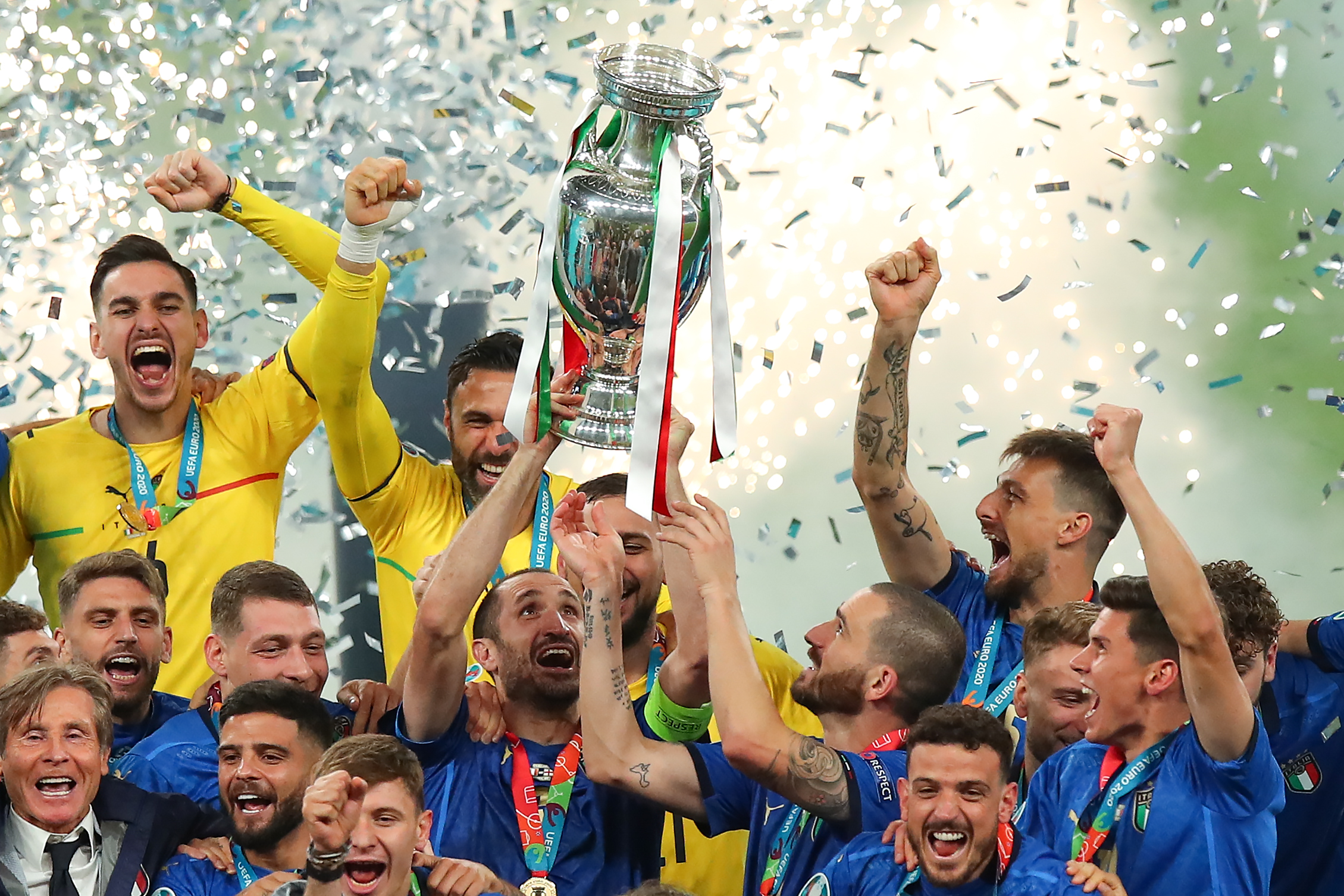 Giorgio Chiellini lifts the European Championship trophy as Italy players celebrate victory over England on penalties in the final of Euro 2020.