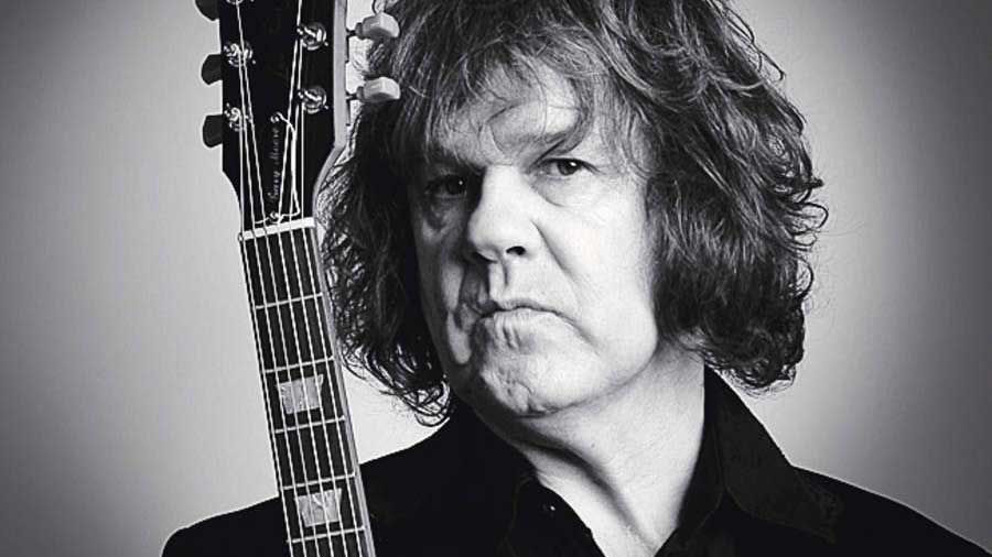 Gary Moore holding a guitar - studio portrait