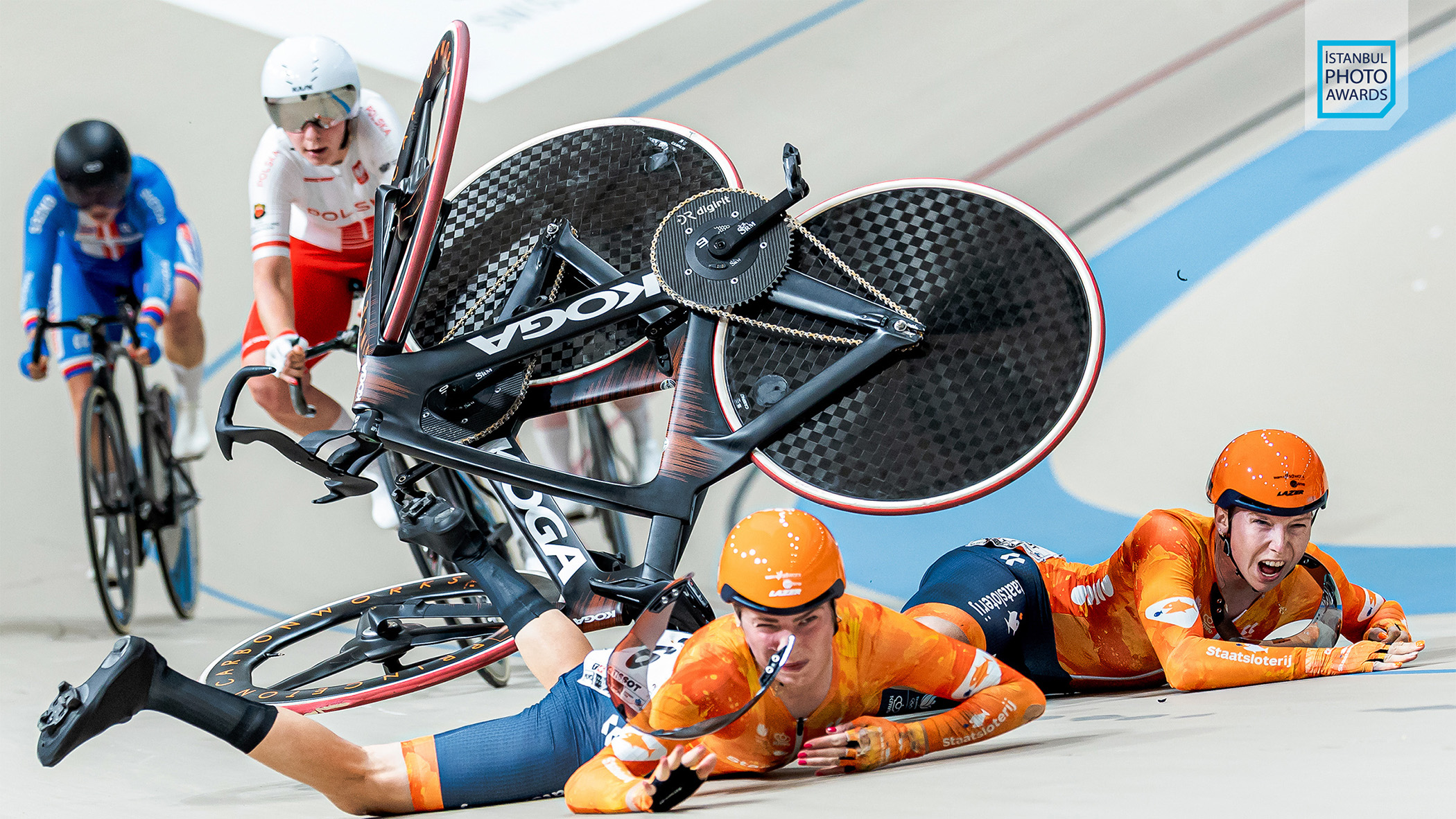 Two cyclists crashing in a velodrome.