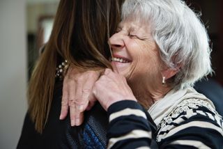 Grandmother and granddaughter hugging as lockdown rules lift