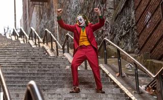 Joaquin Phoenix as Arthur Fleck/Joker in Joker, dancing on the stairs