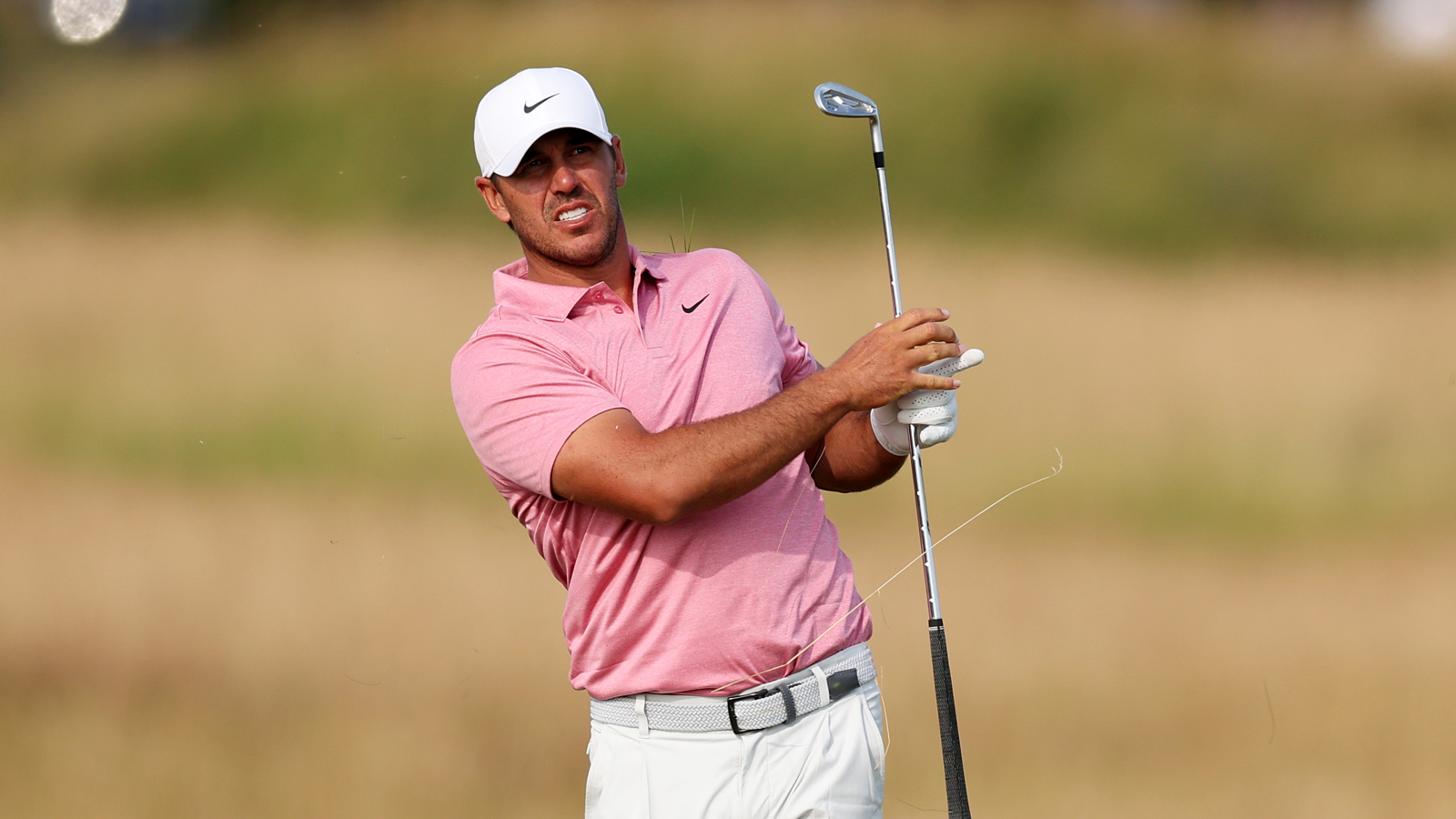 Brooks Koepka reacts to an iron shot