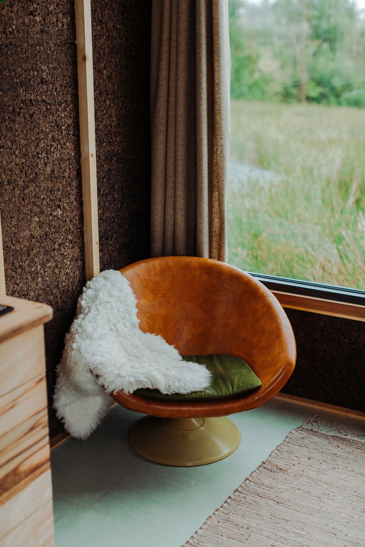 An orange swivel chair in the living area of the tiny eco home