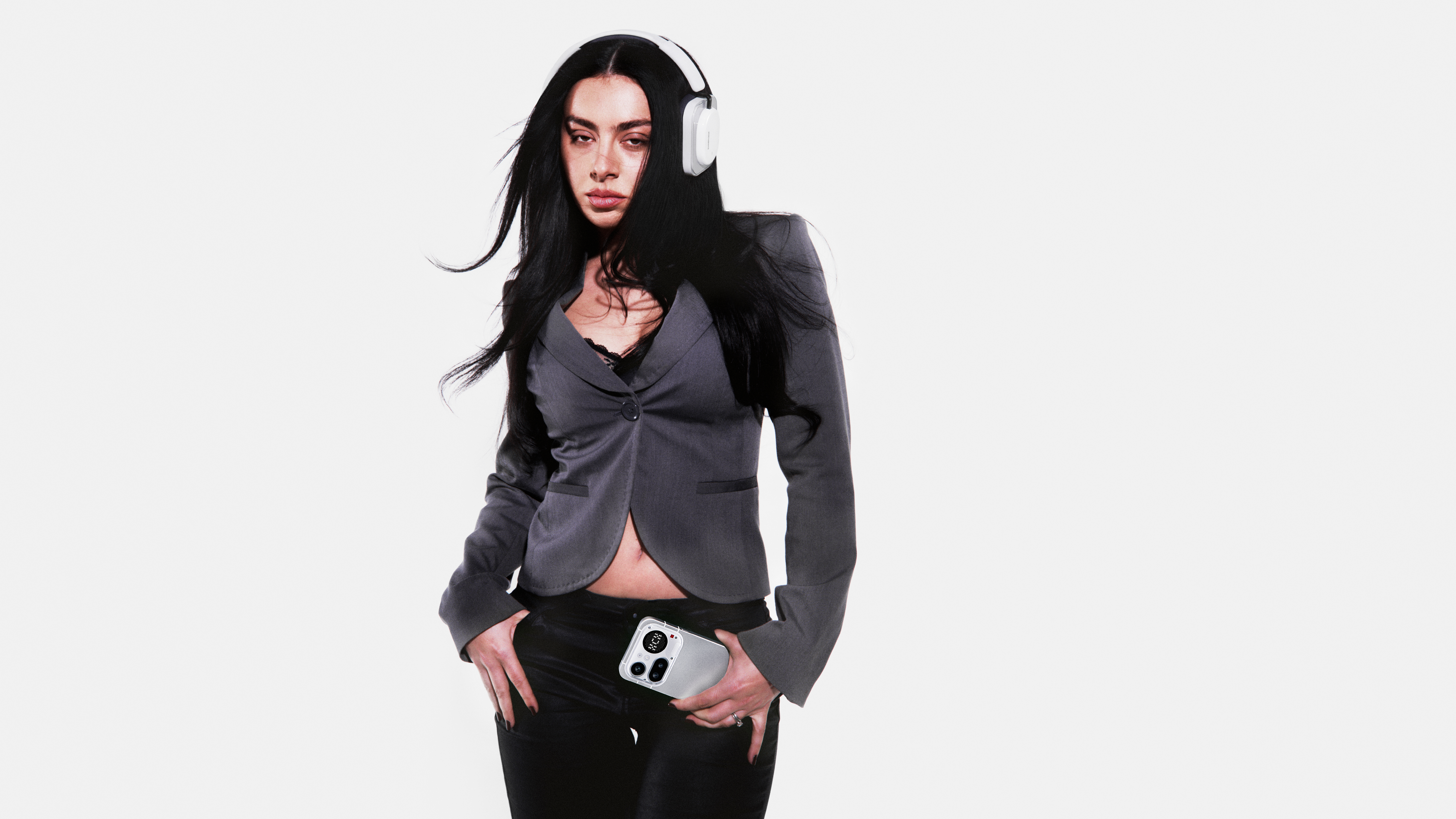 Charli xcx with Nothing phone and headphones