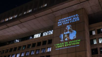 A projection of an Epstein survivor is seen on the FBI building in Washington, D.C.