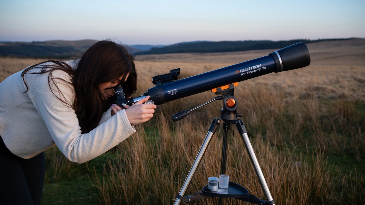 woman using the Celestron AstroMaster LT 70AZ in a field