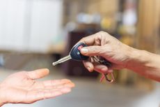 Senior man holding car keys, blurry background