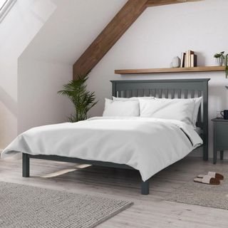 wooden bed frame with white bedding on top
