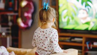 A little girl watching a TV