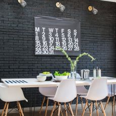 Black brick wall with calendar and white table