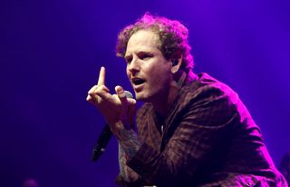 A picture of Corey Taylor making a rude gesture on stage
