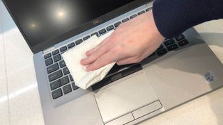 A laptop keyboard being cleaned by a damp towel