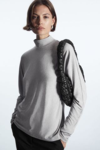 woman wearing roll neck top from the cos sale