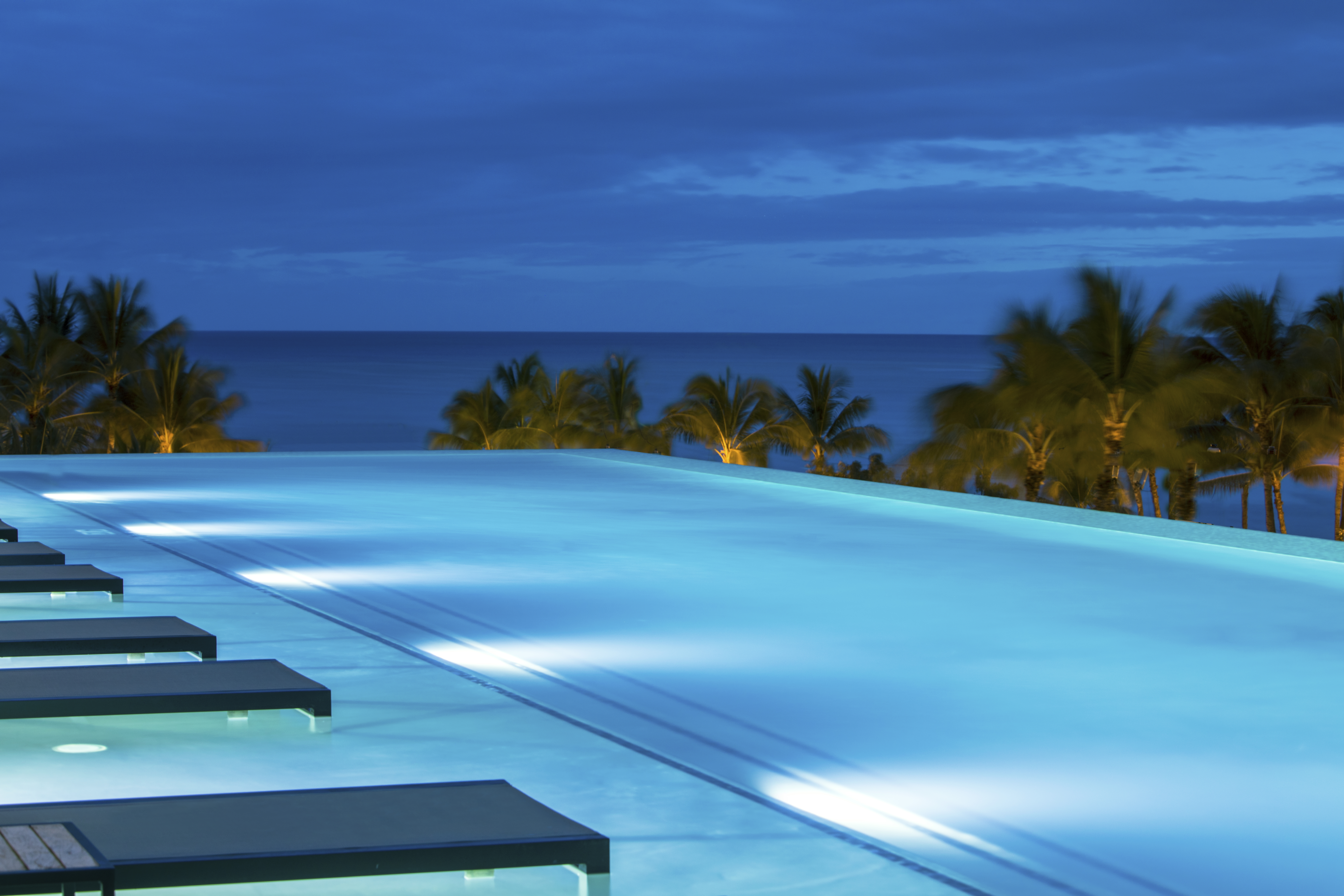 The infinity pool at Alohilani Resort illuminated at night