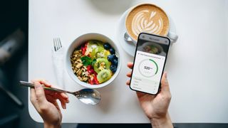 Woman using calorie tracking app to track breakfast