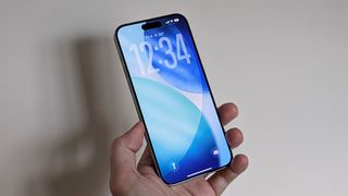 iPhone in hand running iOS 26