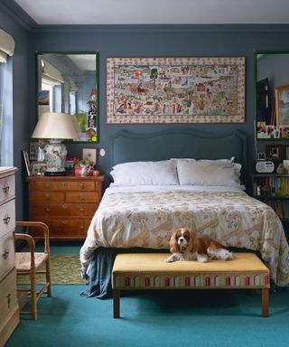 Blue bedroom with wall hanging and patterned bedspread