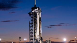 a white rocket topped with a white cone-shaped spacecraft