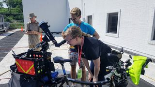Gary Parkerson, "the Pedaling Astronomer" (left), let reporters use his telescope to check out the sunspots on the morning before the eclipse. Gizmodo's Ryan Mandelbaum (that dude with the cool sunglasses) got a look, too!